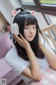 A woman sitting on a bed wearing a pair of headphones.