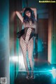 A woman in a fishnet bodystocking posing for a picture.