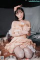 A woman sitting on top of a table holding a piece of bread.