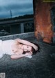 A woman laying on the ground under a bridge.