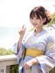 A woman in a blue and yellow kimono posing for a picture.