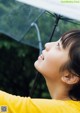 A young girl holding an umbrella in the rain.