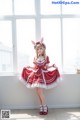 A woman in a red and white dress posing for a picture.